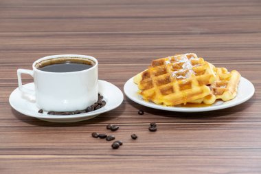 Viyana waffle pudra şekeri serpilir ve bir fincan kahve ile bal ile dökülür.