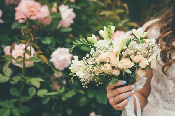 Woman is holding wedding bouquet — Stock Photo, Image