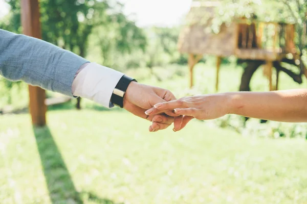 Joven pareja es cogido de la mano — Foto de Stock