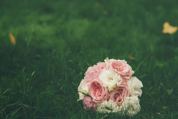 Hochzeitsstrauß Aus Rosa Und Weißen Rosen Auf Gras Liegend — Stockfoto