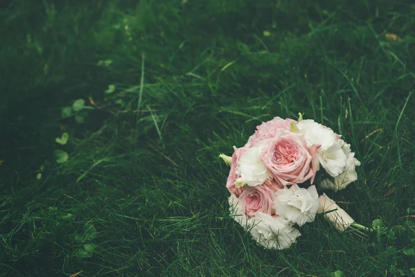 Hochzeitsstrauß Aus Rosa Und Weißen Rosen Auf Gras Liegend — Stockfoto