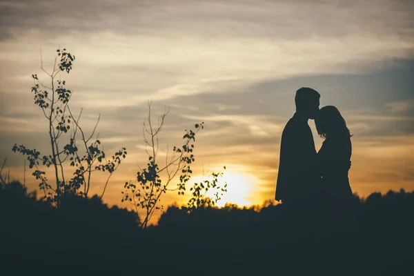 Milující svatební pár objímání sihouette západ slunce — Stock fotografie