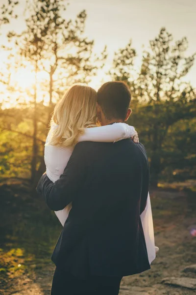 Eheleute umarmen sich bei Sonnenuntergang — Stockfoto