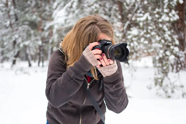 Женщина-фотограф с камерой в снегу — стоковое фото