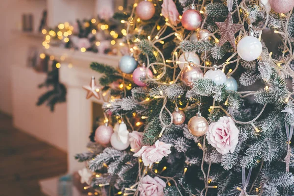 Pastel Christmas tree decorations and yellow Christnas lights in the closeup shot