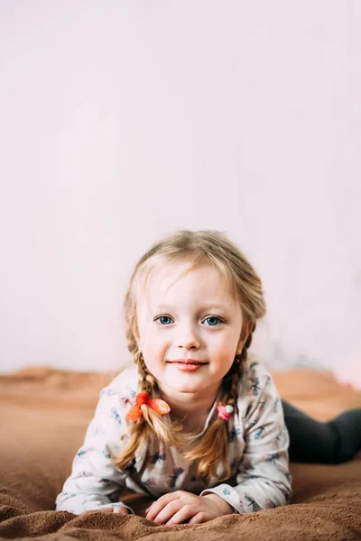Ein Lächelndes Kleines Mädchen Mit Blonden Haaren Liegt Hause Auf — Stockfoto