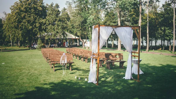 Conceito de casamento com um arco de casamento localizado em um gramado verde — Fotografia de Stock