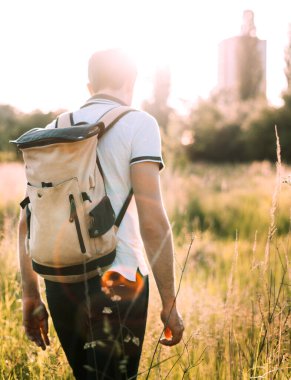 Turistin biri sırtında beyaz tişört ve siyah kot pantolonla sahada yürüyor.. 