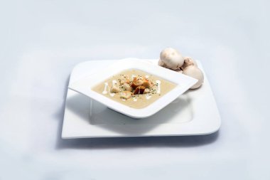 45 derece açı ile minimal Beyaz arka planda ekmek kırıntıları, kekik ile bir mantar çorbası Hero shot