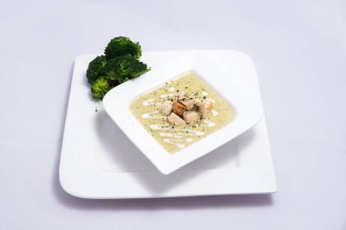 Bir brokoli çorbası, ekmek kırıntıları ile Hero Shot, bir 45 derece ön bakan açı ile minimal Beyaz arka planda kekik