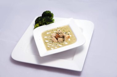 Bir brokoli çorbası, ekmek kırıntıları ile Hero Shot, bir 45 derece ön bakan açı ile minimal Beyaz arka planda kekik