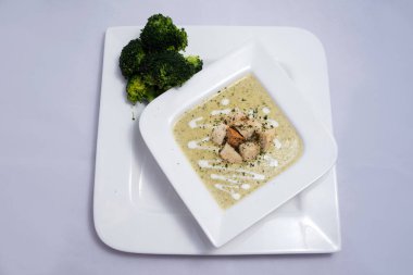 Bir brokoli çorbası, ekmek kırıntıları ile Hero Shot, bir 45 derece ön bakan açı ile minimal Beyaz arka planda kekik