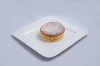 Bir plaka üzerinde bir Pan kek düşük kontrast Hero Shot, bir diyagonal 60 derecelik açı ile minimal Beyaz arka plan üzerinde