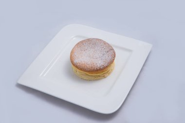 Bir plaka üzerinde bir Pan kek düşük kontrast Hero Shot, bir diyagonal 60 derecelik açı ile minimal Beyaz arka plan üzerinde