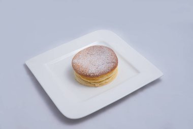 Bir plaka üzerinde bir Pan kek düşük kontrast Hero Shot, bir diyagonal 60 derecelik açı ile minimal Beyaz arka plan üzerinde