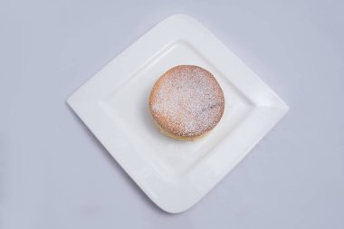 Bir plaka üzerinde bir Pan kek düşük kontrast Hero Shot, bir diyagonal 60 derecelik açı ile minimal Beyaz arka plan üzerinde