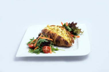 Sebze ile yumurta dolu kruvasan ile bir kahvaltı tabağı düşük kontrast görüntü-havuç, domates, ön perspektiften 30 derecelik bir açı ile minimal Beyaz arka planda marul