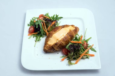 Sebze ile peynir dolu kruvasan ile bir kahvaltı tabağı düşük kontrast görüntü-havuç, domates, en az beyaz arka planda marul bir 30 derece açısı ile öne yakınlaştırılmış perspektif