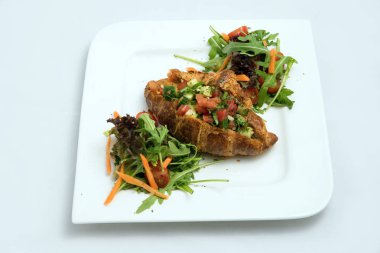 Sebze ile sebze dolu kruvasan ile bir kahvaltı tabağı bir düşük kontrast Hero çekim-havuç, domates, çapraz perspektif 30 derecelik bir açı ile minimal Beyaz arka planda marul.