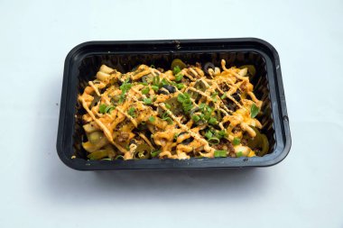 Yüksek kontrastlı Hero shot bir Take-Away Hot Loaded patates / cips peynir, kıyma, zeytin, jalapeno, sos & kekik, dikey perspektiften 75 derecelik açı ile minimal beyaz arka plan üzerinde.
