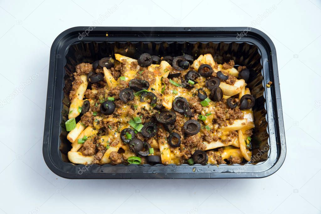 A high contrast Hero shot of a Take-Away Hot Loaded fries / chips with ground meat, olives, cheese, jalapeno, sauce & oregano, on a minimal white background with a 90 degree angle from zoomed  vertical perspective.