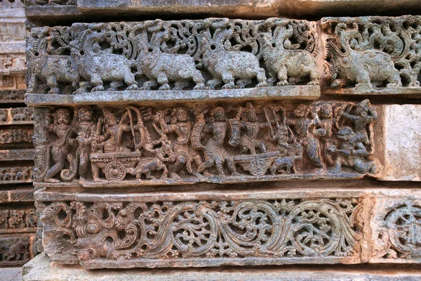 Frizleri tapınağın binasında. Kedareshwara Tapınağı, Halebidu, Karnataka, Hindistan. Üstten - Makara, Ramayana, savaş atak kayar