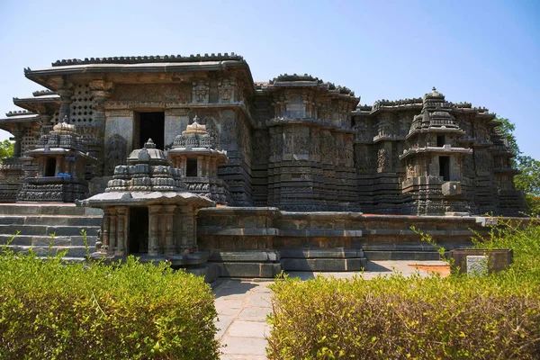 Kuzey girişinde solda, cephe ve süslü duvar paneli kabartma kuzey tarafının Hoysaleshwara tapınak kompleksi, Halebid, Karnataka, Hindistan. Kuzey görünümünden.