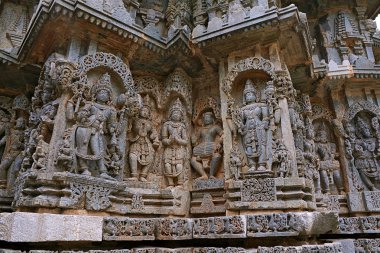 Süslü duvar paneli kabartma gelen tasvir yaptı Bhairava, diğer tanrılar, bir drumer ve Lord Vishnu, Kedareshwara Tapınağı, Halebidu, Karnataka, Hindistan.
