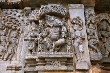 Sol Kamdev ve eşi Rati resmeden ve Ganesha dans süslü duvar paneli kabartma. Kedareshwara Tapınağı, Halebidu, Karnataka, Hindistan.