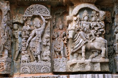 Süslü duvar paneli kabartma gelen tasvir yaptı Krishna Govardhan Giridhari ve Shiva-Parvati Nandi üzerinde oturmuş olarak Kedareshwara Tapınağı, Halebidu, Karnataka, Hindistan. 