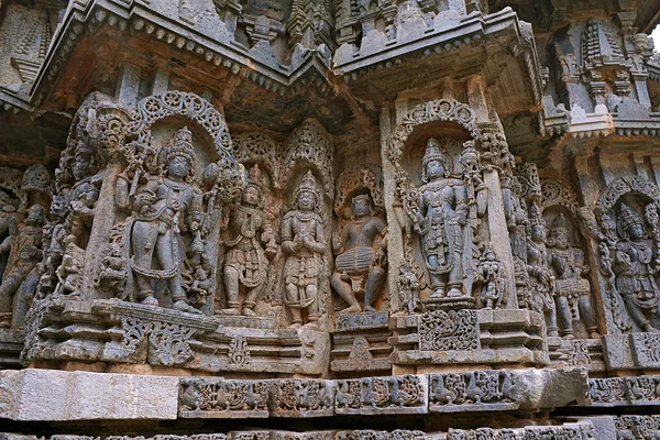 Ornate wall panel reliefs depicting from left Bhairava, Other deities, a drumer and Lord Vishnu, Kedareshwara temple, Halebidu, Karnataka, India. — Stock Image Ornate Wall Panel Reliefs Depicting Left Bhairava Other Deities Drumer Stock Picture
