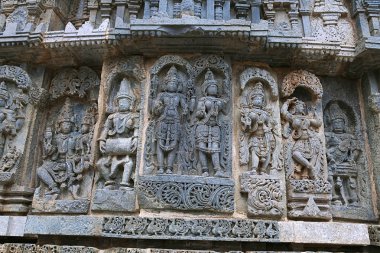 Süslü duvar paneli kabartma gelen tasvir Shiva-Parvati, bir drumer, Lakshmi-Narayana ve diğer tanrılar yaptı Kedareshwara Tapınağı, Halebidu, Karnataka, Hindistan.
