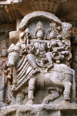 Shiva-Parvati Nandi üzerinde oturmuş tasvir eden süslü duvar paneli kabartma Kedareshwara Tapınağı, Halebidu, Karnataka, Hindistan. 