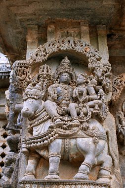 Shiva-Parvati Nandi üzerinde oturan Kuzey duvarı, Kedareshwara Tapınağı, tasvir eden süslü duvar paneli kabartma Halebidu, Karnataka, Hindistan.