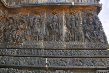 Soldan bir tanrıça, Lord Brahma, Mahesh Shiva, lord Vishnu ve Shiva-Parvati, tasvir eden süslü duvar paneli kabartma Hoysaleshwara Tapınağı, Halebidu, Karnataka, Hindistan.