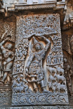 Lord Krishna Govardhan Girdhari, Batı yan duvar, Hoysaleshwara Tapınağı, Halebidu, Karnataka, Hindistan olarak heykeli.