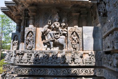 SK Tarih heykeller ade, Batı Yan duvarlar. Nandi oturan Shiva-Parvati. Hoysaleshwara Tapınağı, Halebidu, Karnataka, Hindistan. 
