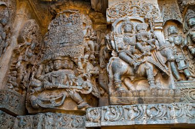 Batı yan duvarlarda heykeller. Sol tarafta Kailasa kaldırma Ravana ve Shiva-Parvati Nadi sağ üzerinde. Hoysaleshwara Tapınağı, Halebidu, Karnataka, Hindistan. Batıdan görüntülemek.