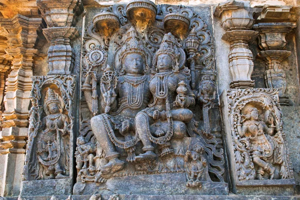 Sculptures on the facade, west side walls. Shiva-Parvati. Hoysaleshwara temple, Halebidu, Karnataka, India. view from West