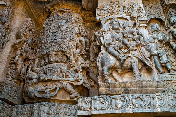 Batı yan duvarlarda heykeller. Sol tarafta Kailasa kaldırma Ravana ve Shiva-Parvati Nadi sağ üzerinde. Hoysaleshwara Tapınağı, Halebidu, Karnataka, Hindistan. Batıdan görüntülemek.
