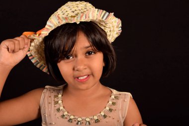 Kamera fonunda siyah, Pune, Maharashtra bakarak bir şapka ile küçük kız