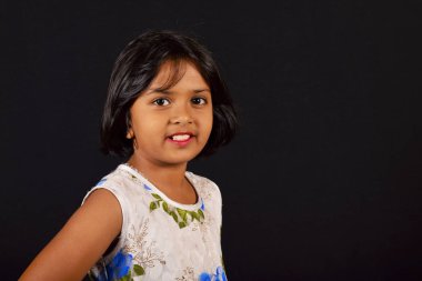 Kamera fonunda siyah, Pune, Maharashtra bakarak sevimli bir gülümseme ile küçük kız