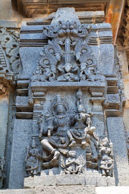 Süslü duvar paneli kabartma Lord Vishnu ile tasvir eden eşi onun kucağına oturan Lakshmi Keşava Tapınağı, Belur, Karnataka, Hindistan. 