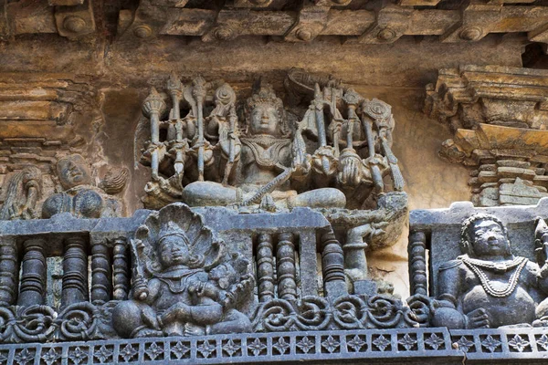 Ornate wall panel reliefs depicting Lord Vishnu as Narayana, the Supreme God, Chennakesava temple, Belur, Karnataka, india. Sixteen-armed Narayana is seated on a lotus that is upheld by a four-armed Garuda. — Stock Image Ornate Wall Panel Reliefs Depicting Lord Vishnu Narayana Supreme God Stock Image