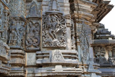 Süslü duvar paneli kabartma tasvir eden, sol, Sundari, Nagas, Gajasurasamhara, Bramha ve Narayana extre sağ olarak Shiva. Keşava Tapınağı, Belur, Karnataka, Hindistan. Batıdan görünümü.