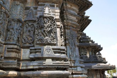 Süslü duvar paneli kabartma tasvir eden, sol, Sundari, Nagas, Gajasurasamhara, Bramha ve Narayana extre sağ olarak Shiva. Keşava Tapınağı, Belur, Karnataka, Hindistan. Batıdan görünümü.