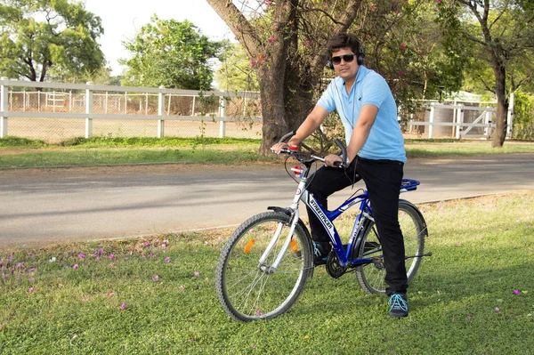 年轻人穿着护目镜骑自行车和听音乐在公园 — 图库照片