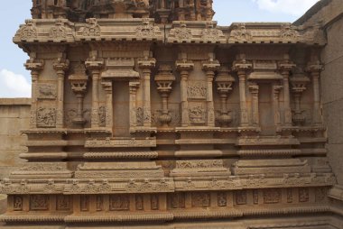 Outer wall of the Amman shrine, Hazara Rama Temple. Royal Center. Hampi, Karnataka, India. The bas-reliefs depicts the devakoshtas falnked by Vaishnava dvarpalas and well-proportioned kumbhapanjaras. clipart