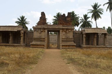 Sigarasız, iç avlu, cloisters veya sütunlu veranda ve Doğu gopura oyma sütunlar. Achyuta Raya Tapınağı, Hampi, Karnataka, Hindistan. Kutsal merkezi. Batı yakasından görüntülemek. 