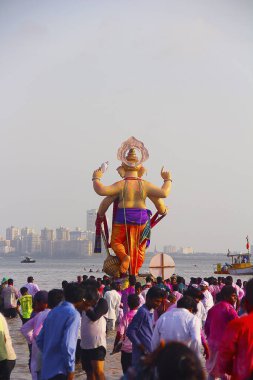 MUMBAI, MAHARASHTRA, September 2017, People carry Ganapati idol for immersion into the sea in wooden boats at Girgaum Chowpatty clipart
